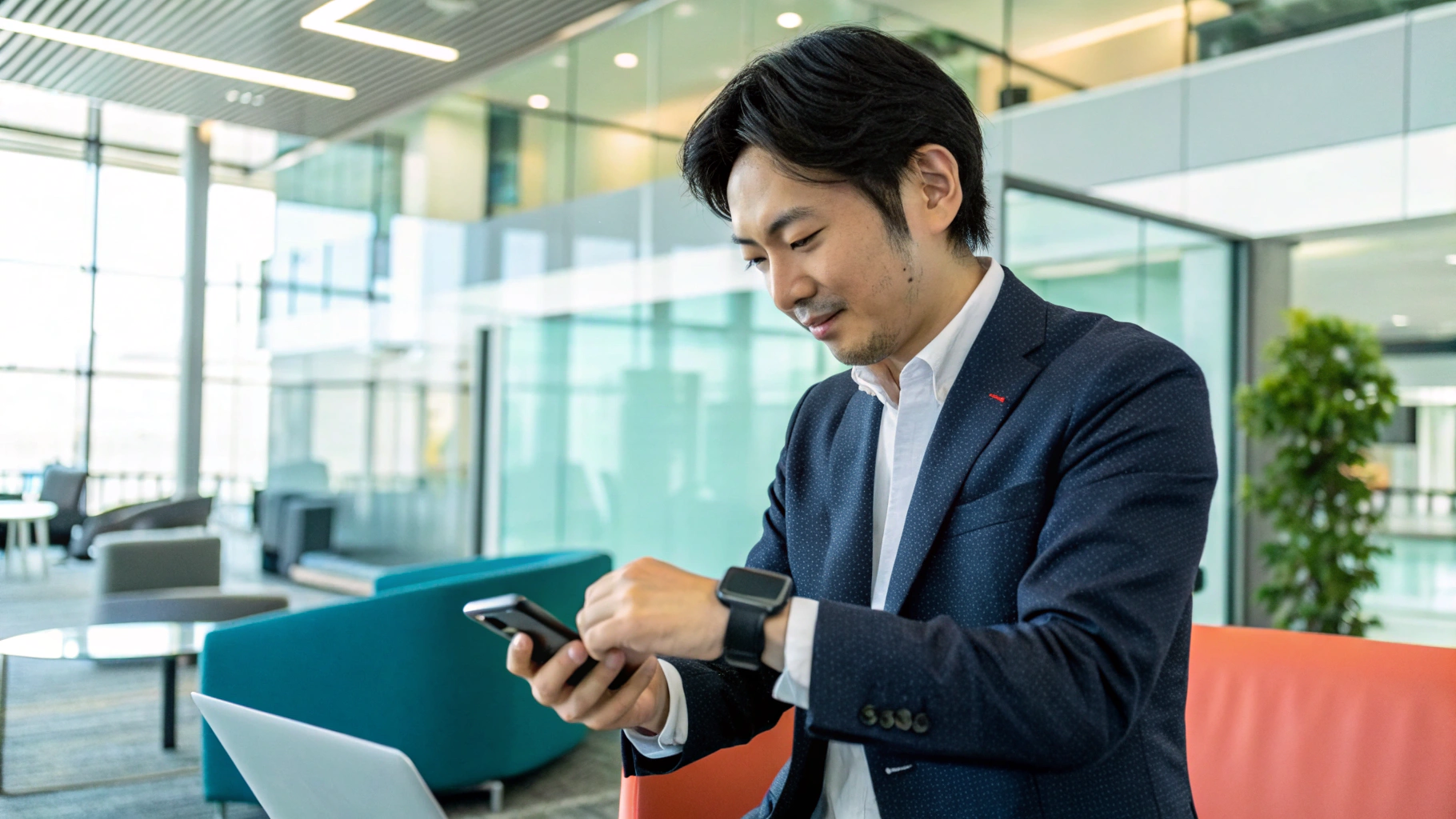 オフィスでスマホを見るスーツ姿の男性